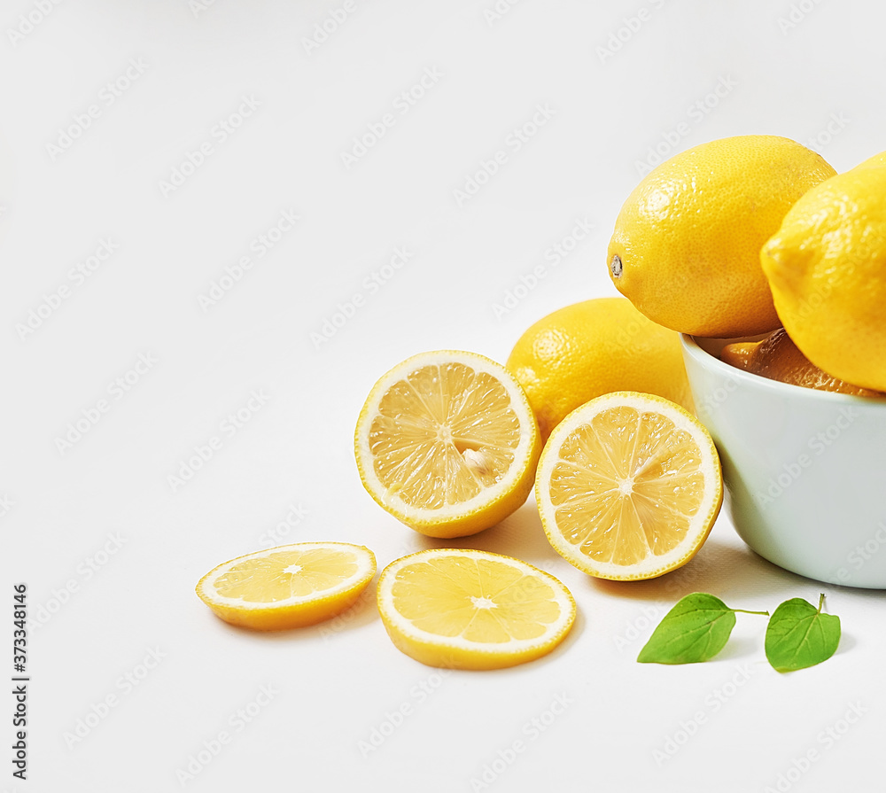 Lemons background. Group of lemons with leaves on white background. Citruses and vitamins. Creative layout made of lemon and leaves. Flat lay. Food concept. Vegetarianism and veganism. Summer