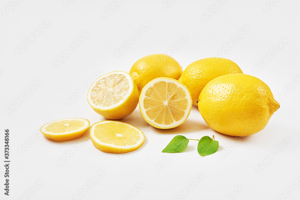 Lemons background. Group of lemons with leaves on white background. Citruses and vitamins. Creative layout made of lemon and leaves. Flat lay. Food concept. Vegetarianism and veganism. Summer Lemons background. Group of lemons with leaves on white background. Citruses and vitamins. Creative layout made of lemon and leaves. Flat lay. Food concept. Vegetarianism and veganism. Summer