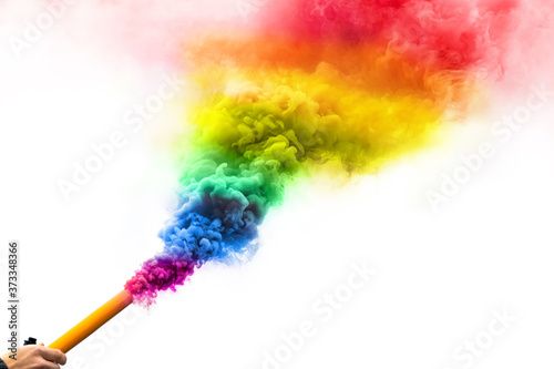 Lit rainbow smoke bomb in hand isolated on white background. Abstract LGBT art colored smoke, copyspace. Gay smoke flag, LGBT pride photo