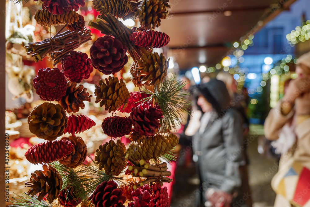 Naklejka premium Selective focus at hanging dry natural Mini Pine Nuts Cedar for decoration, in front of stall at Weihnachtsmarkt, Christmas Market.