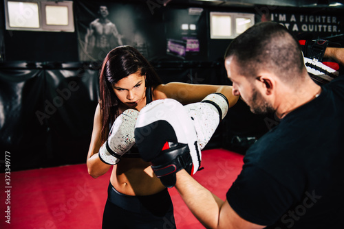Female fighter sparing with her coach in the gym. © Daniel