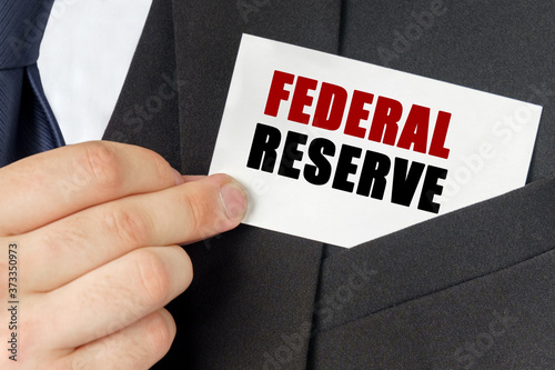 Businessman holds a card with the text - FEDERAL RESERVE