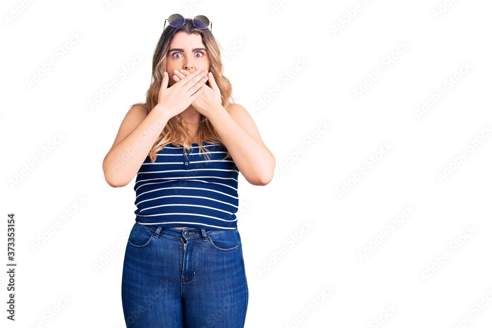 Young caucasian woman wearing casual clothes and sunglasses shocked covering mouth with hands for mistake. secret concept. Young caucasian woman wearing casual clothes and sunglasses shocked covering mouth with hands for mistake. secret concept.