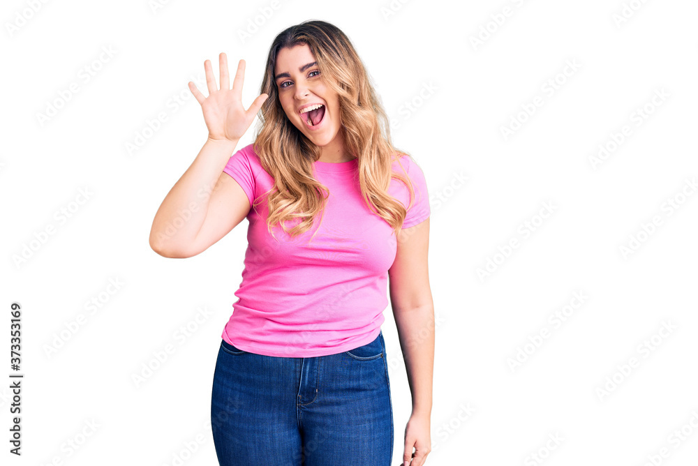 Young caucasian woman wearing sportswear showing and pointing up with fingers number five while smiling confident and happy. Young caucasian woman wearing sportswear showing and pointing up with fingers number five while smiling confident and happy.