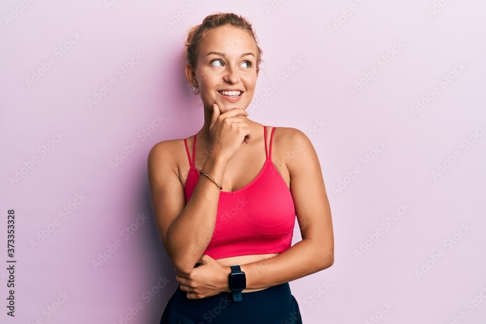 Beautiful caucasian woman wearing sportswear with hand on chin thinking about question, pensive expression. smiling with thoughtful face. doubt concept. Beautiful caucasian woman wearing sportswear with hand on chin thinking about question, pensive expression. smiling with thoughtful face. doubt concept.