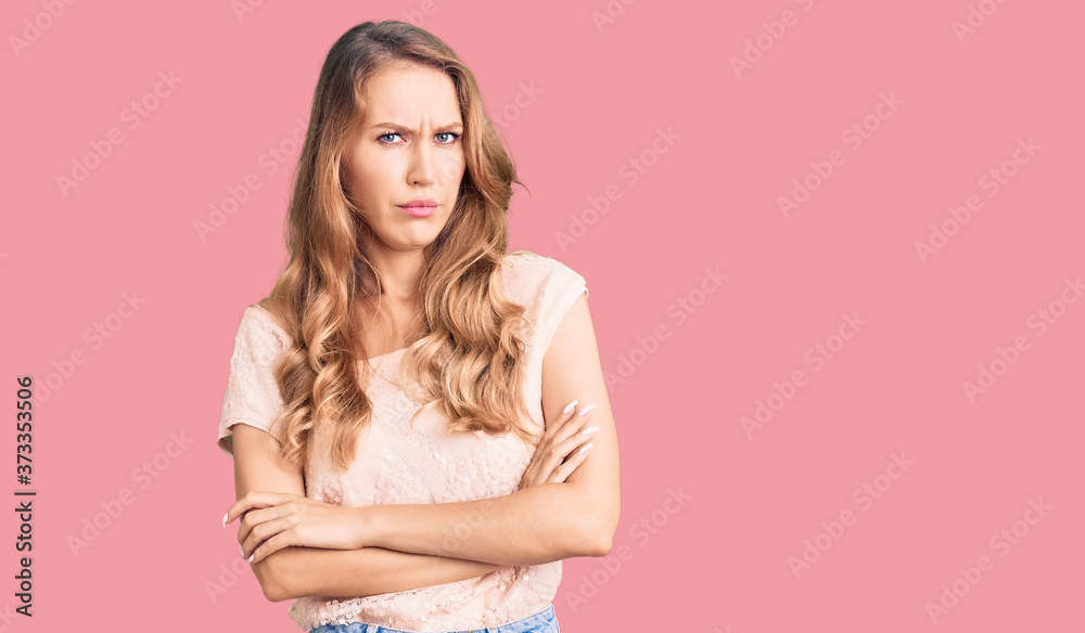 Young beautiful caucasian woman with blond hair wearing casual clothes skeptic and nervous, disapproving expression on face with crossed arms. negative person. Young beautiful caucasian woman with blond hair wearing casual clothes skeptic and nervous, disapproving expression on face with crossed arms. negative person.
