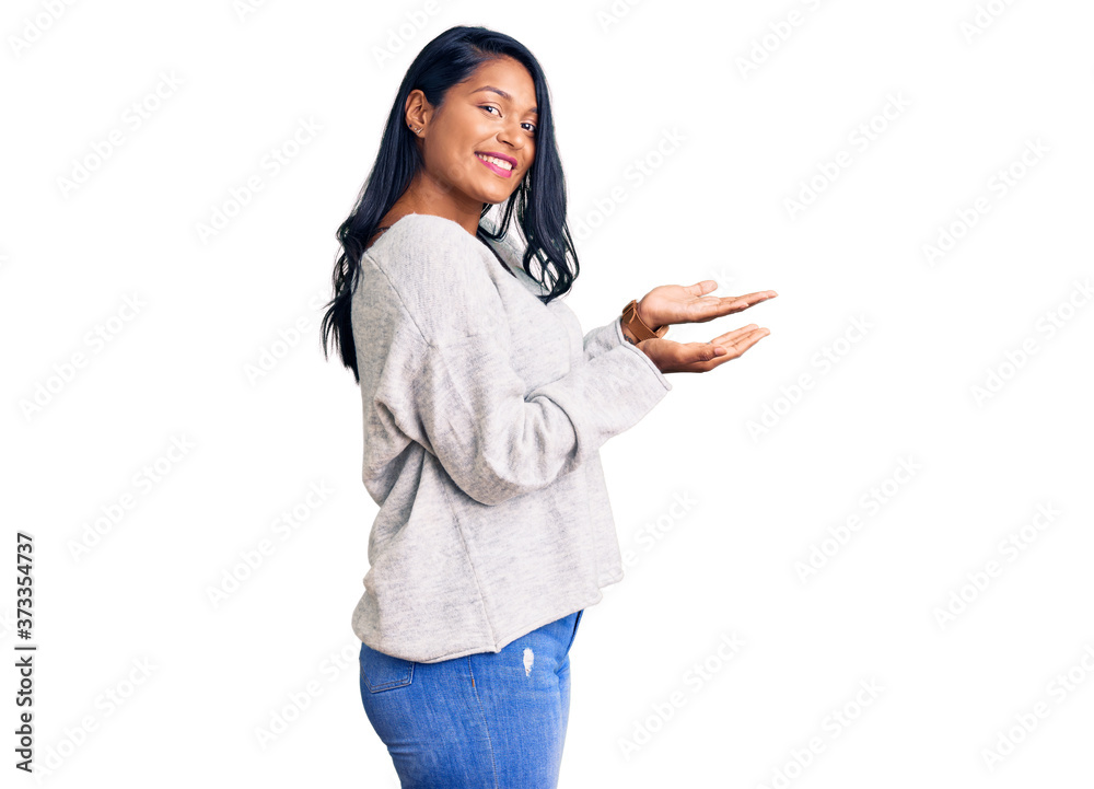 Hispanic woman with long hair wearing casual clothes pointing aside with hands open palms showing copy space, presenting advertisement smiling excited happy Hispanic woman with long hair wearing casual clothes pointing aside with hands open palms showing copy space, presenting advertisement smiling excited happy