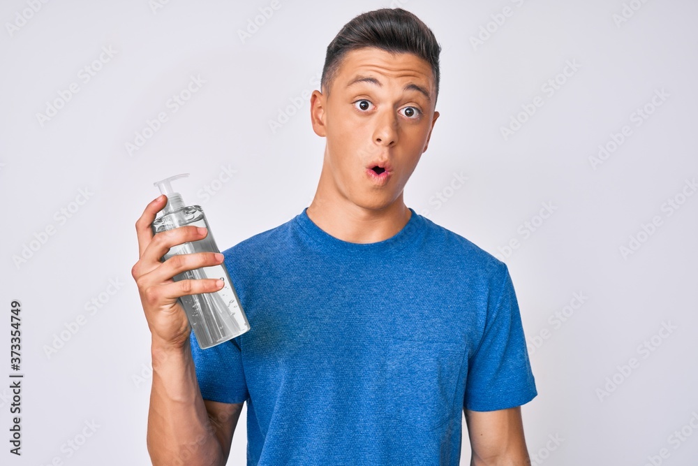 Young hispanic boy using hand sanitizer gel scared and amazed with open mouth for surprise, disbelief face Young hispanic boy using hand sanitizer gel scared and amazed with open mouth for surprise, disbelief face