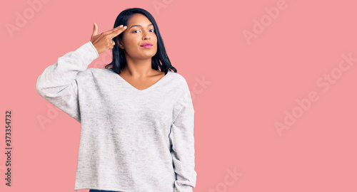Fotografija Hispanic woman with long hair wearing casual clothes shooting and killing oneself pointing hand and fingers to head like gun, suicide gesture