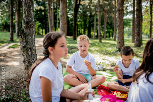 School children in white t shirt eating lunch during their lunch break at school