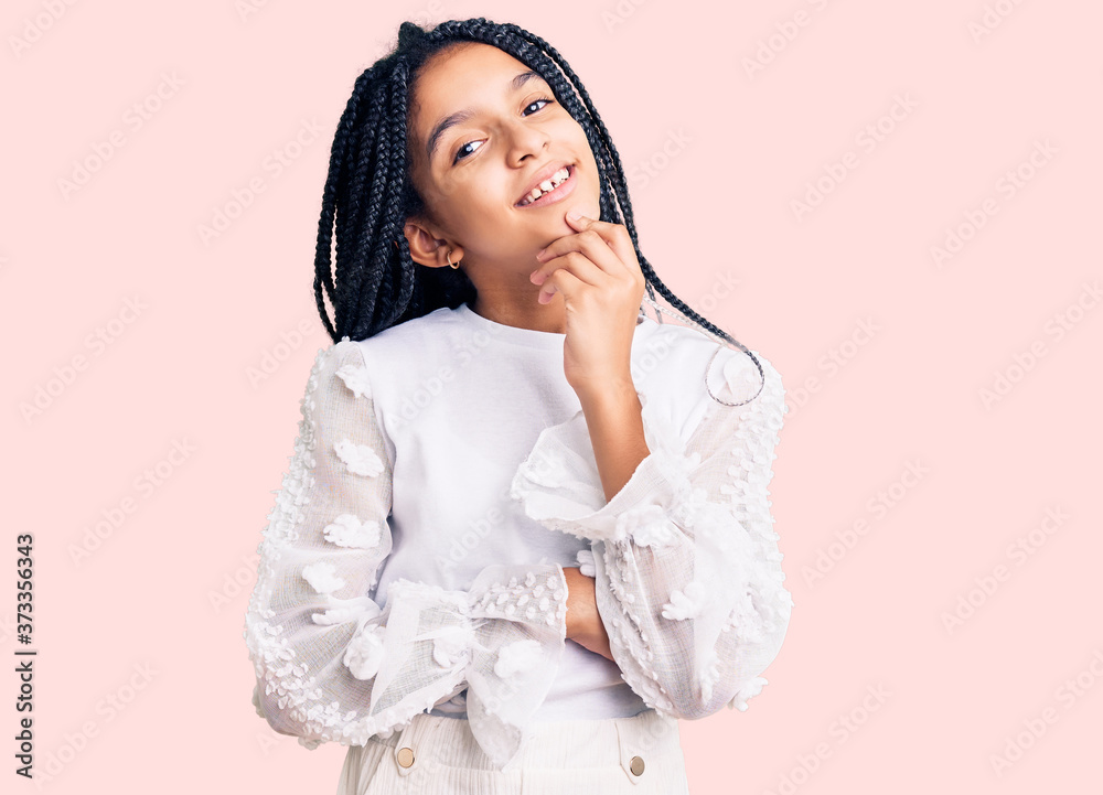 Cute african american girl wearing casual white tshirt looking confident at the camera with smile with crossed arms and hand raised on chin. thinking positive. Cute african american girl wearing casual white tshirt looking confident at the camera with smile with crossed arms and hand raised on chin. thinking positive.