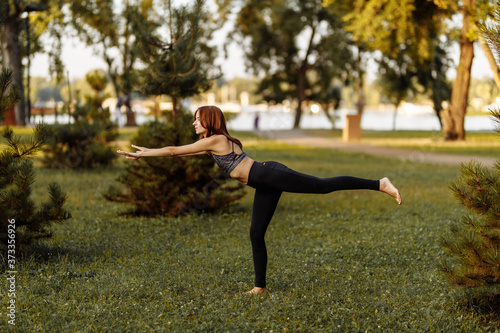 Young girl doing physical exercises in nature.