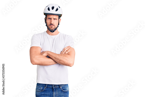 Young handsome man wearing bike helmet skeptic and nervous, disapproving expression on face with crossed arms. negative person. © Krakenimages.com