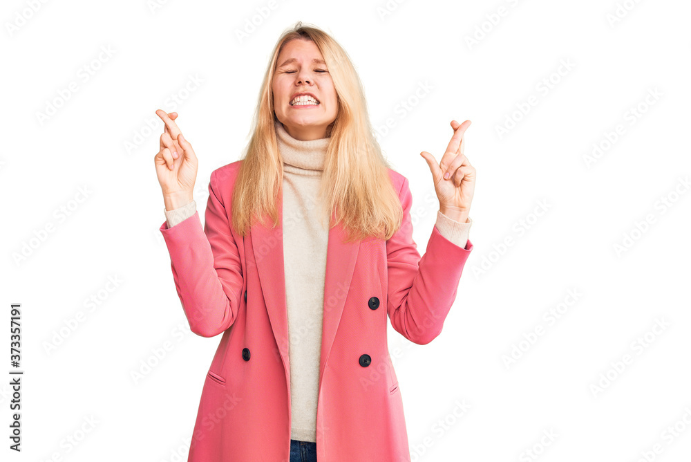 Young beautiful blonde woman wearing elegant clothes gesturing finger crossed smiling with hope and eyes closed. luck and superstitious concept. Young beautiful blonde woman wearing elegant clothes gesturing finger crossed smiling with hope and eyes closed. luck and superstitious concept.