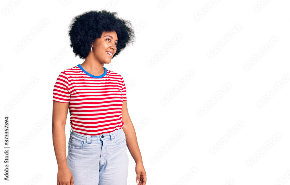 Young african american girl wearing casual clothes looking away to side with smile on face, natural expression. laughing confident. Young african american girl wearing casual clothes looking away to side with smile on face, natural expression. laughing confident.