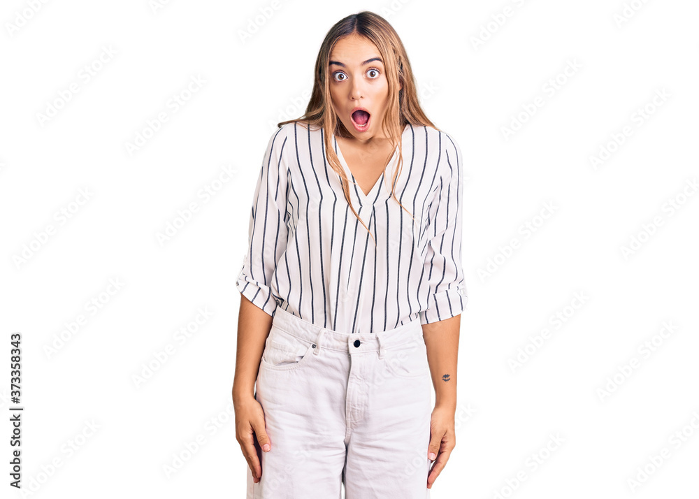 Young beautiful blonde woman wearing casual clothes scared and amazed with open mouth for surprise, disbelief face Young beautiful blonde woman wearing casual clothes scared and amazed with open mouth for surprise, disbelief face