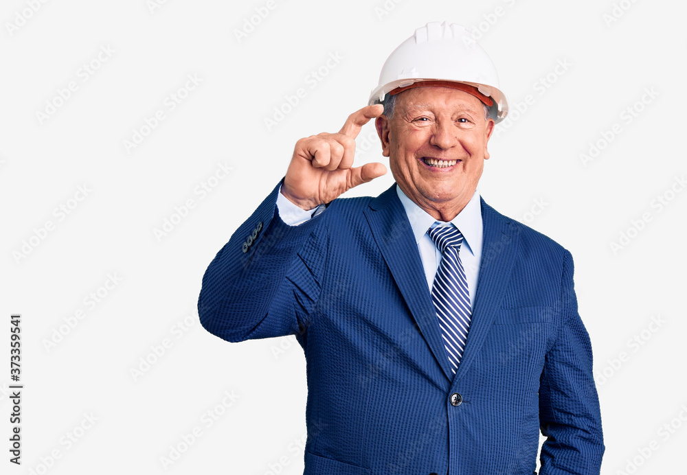 Senior handsome grey-haired man wearing suit and architect hardhat smiling and confident gesturing with hand doing small size sign with fingers looking and the camera. measure concept. Senior handsome grey-haired man wearing suit and architect hardhat smiling and confident gesturing with hand doing small size sign with fingers looking and the camera. measure concept.
