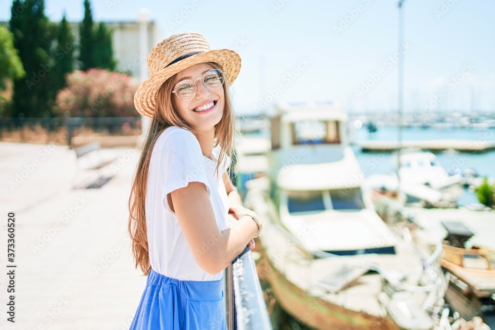 Young blonde woman on vacation smiling happy leaning on balustrade at street of city