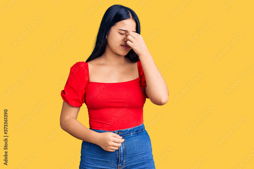 Young beautiful asian girl wearing casual clothes tired rubbing nose and eyes feeling fatigue and headache. stress and frustration concept.