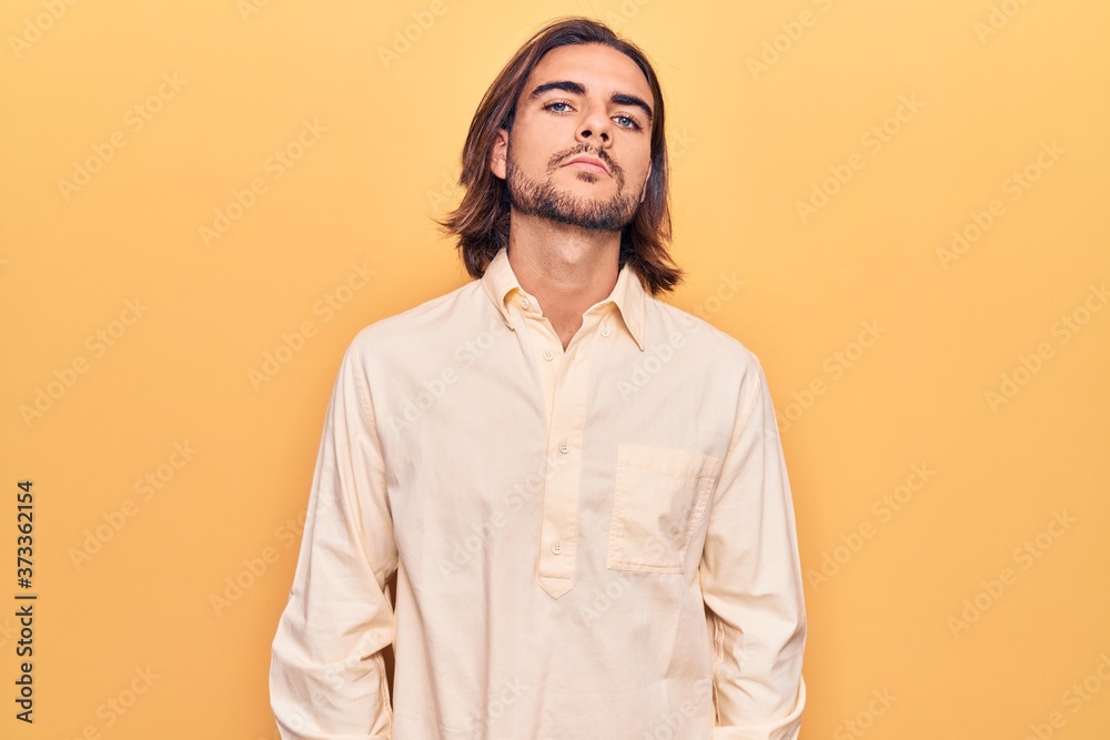 Fototapeta premium Young handsome man wearing business clothes relaxed with serious expression on face. simple and natural looking at the camera.