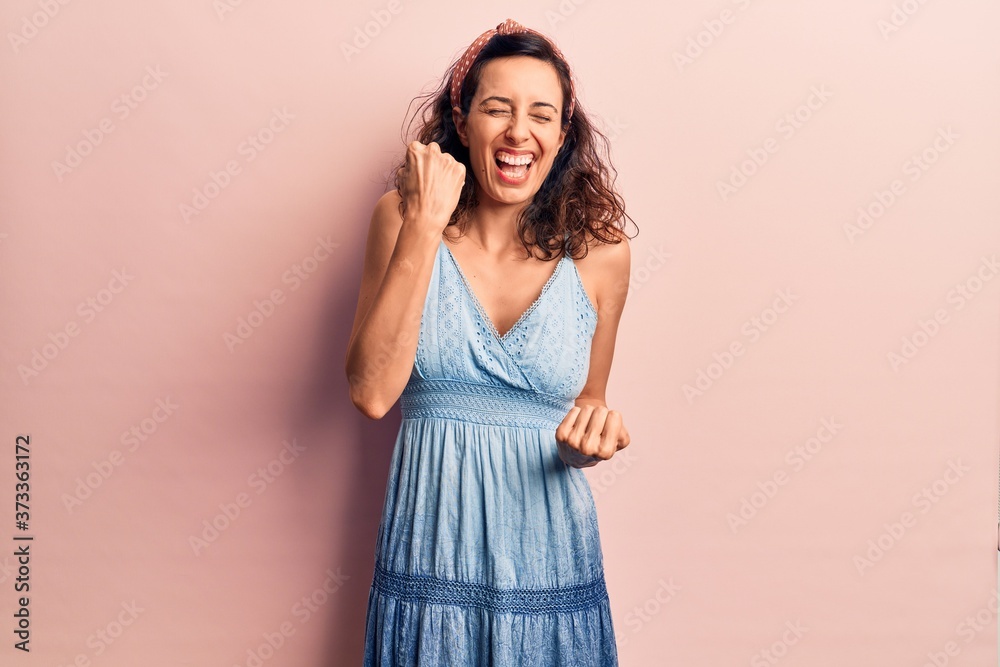 Young beautiful hispanic woman wearing casual dress and diadem celebrating surprised and amazed for success with arms raised and eyes closed Young beautiful hispanic woman wearing casual dress and diadem celebrating surprised and amazed for success with arms raised and eyes closed