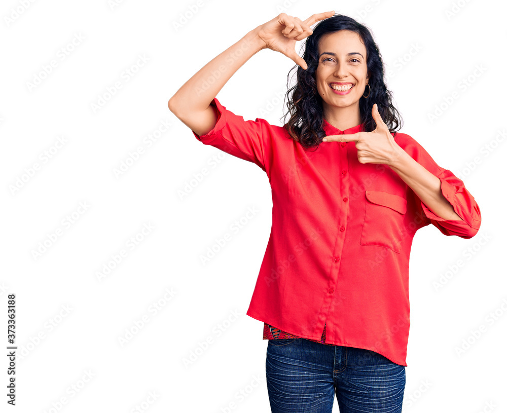 Fototapeta premium Young beautiful hispanic woman wearing casual clothes smiling making frame with hands and fingers with happy face. creativity and photography concept.