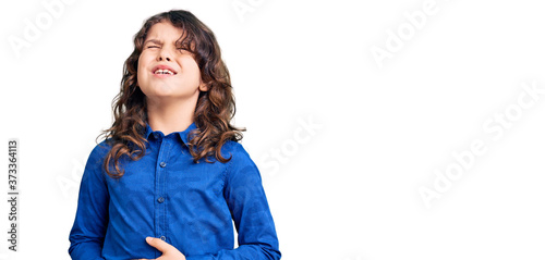 Cute child with long hair wearing casual clothes with hand on stomach because nausea, painful disease feeling unwell. ache concept.
