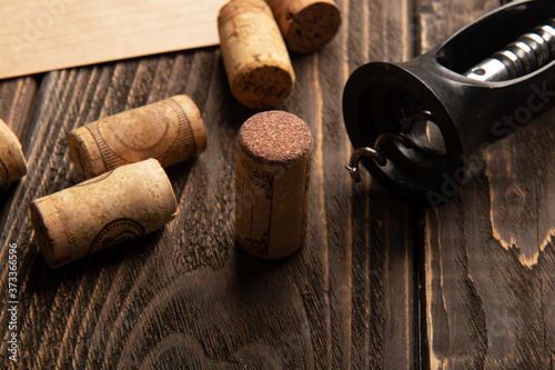 Wine corks and corkscrew on wooden table