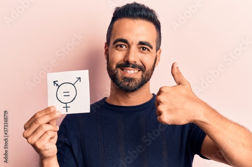 Fototapeta Young hispanic man holding transgender symbol reminder smiling happy and positiv
