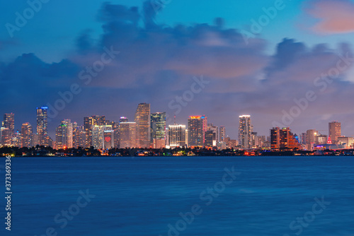 Miami skyline. Skyline city miami lighting lights sea ocean sunset night cityscape buildings downtown, architecture skyscraper dusk panorama. © Volodymyr