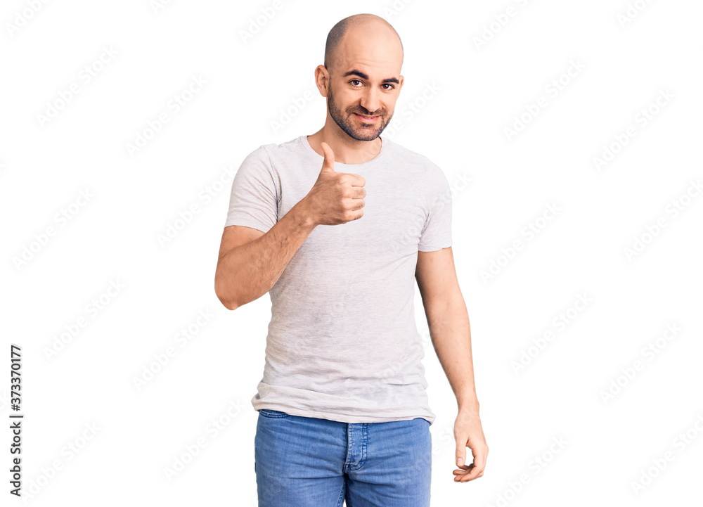 Young handsome man wearing casual t shirt doing happy thumbs up gesture with hand. approving expression looking at the camera showing success. Young handsome man wearing casual t shirt doing happy thumbs up gesture with hand. approving expression looking at the camera showing success.