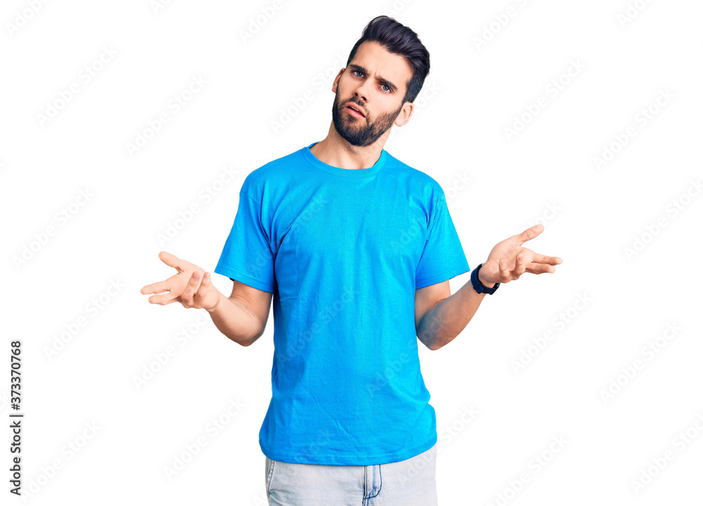 Young handsome man with beard wearing casual t-shirt clueless and confused with open arms, no idea concept. Young handsome man with beard wearing casual t-shirt clueless and confused with open arms, no idea concept.