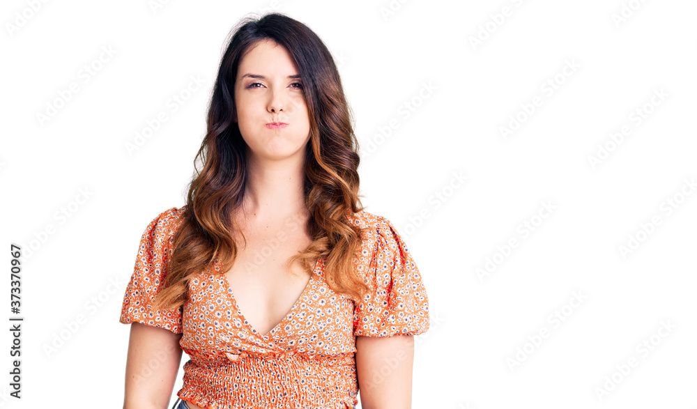Beautiful young brunette woman wearing casual clothes puffing cheeks with funny face. mouth inflated with air, crazy expression. Beautiful young brunette woman wearing casual clothes puffing cheeks with funny face. mouth inflated with air, crazy expression.