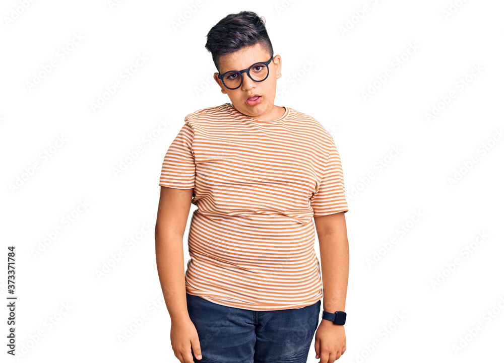 Little boy kid wearing casual clothes and glasses in shock face, looking skeptical and sarcastic, surprised with open mouth Little boy kid wearing casual clothes and glasses in shock face, looking skeptical and sarcastic, surprised with open mouth