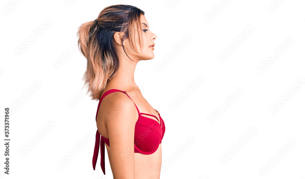 Obraz premium Young beautiful woman wearing bikini looking to side, relax profile pose with natural face and confident smile.