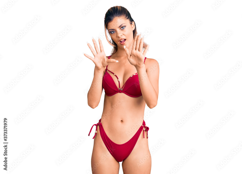 Young beautiful woman wearing bikini doing stop gesture with hands palms, angry and frustration expression Young beautiful woman wearing bikini doing stop gesture with hands palms, angry and frustration expression