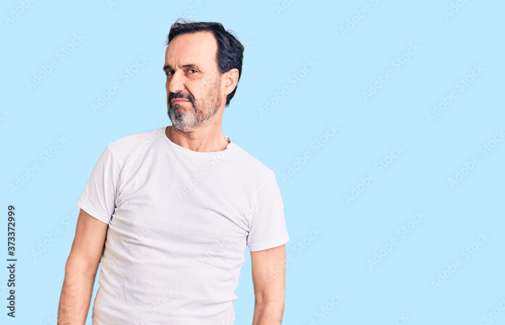 Obraz premium Middle age handsome man wearing casual t-shirt looking sleepy and tired, exhausted for fatigue and hangover, lazy eyes in the morning.