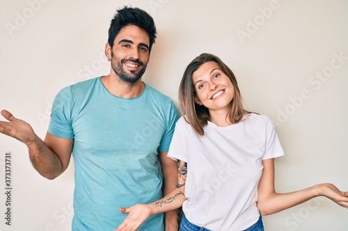 Beautiful young couple of boyfriend and girlfriend together smiling showing both hands open palms, presenting and advertising comparison and balance