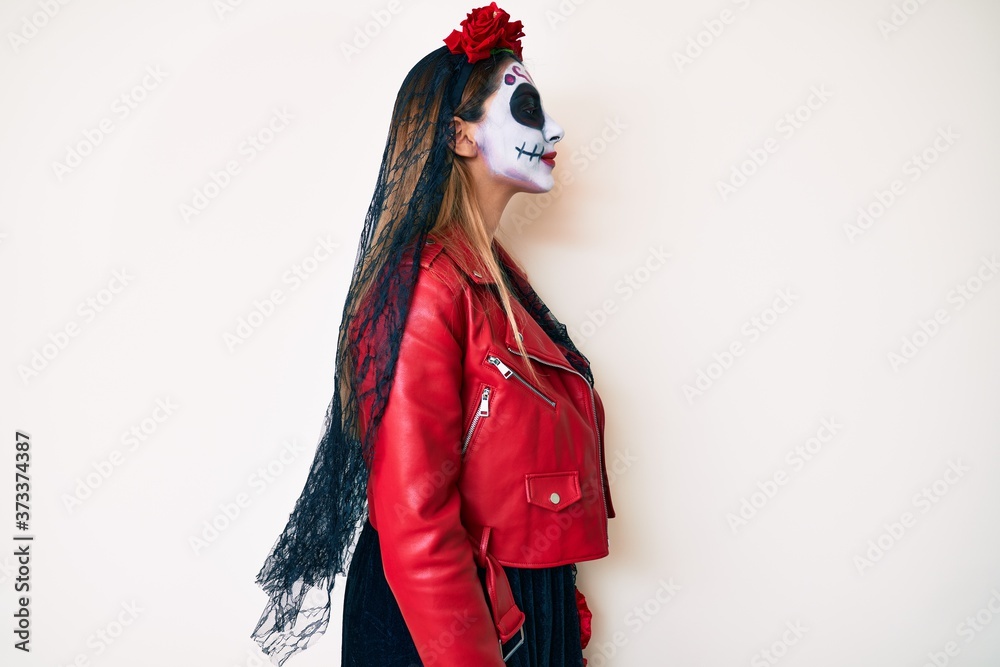 Woman wearing day of the dead costume over white looking to side, relax profile pose with natural face and confident smile.