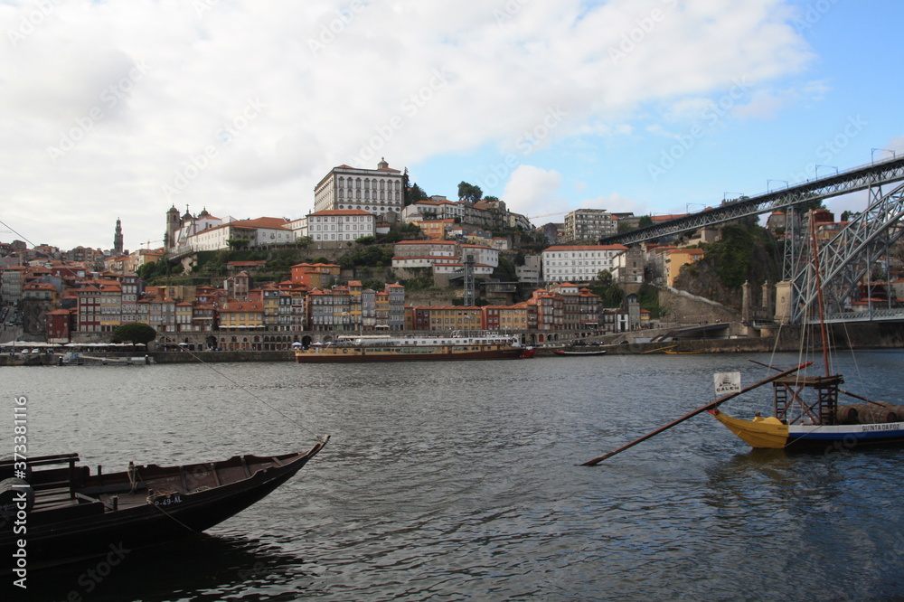 Obraz premium Dom Luis I bridge and traditional boats with wine barrels on Rio Douro river in Porto, Portugal