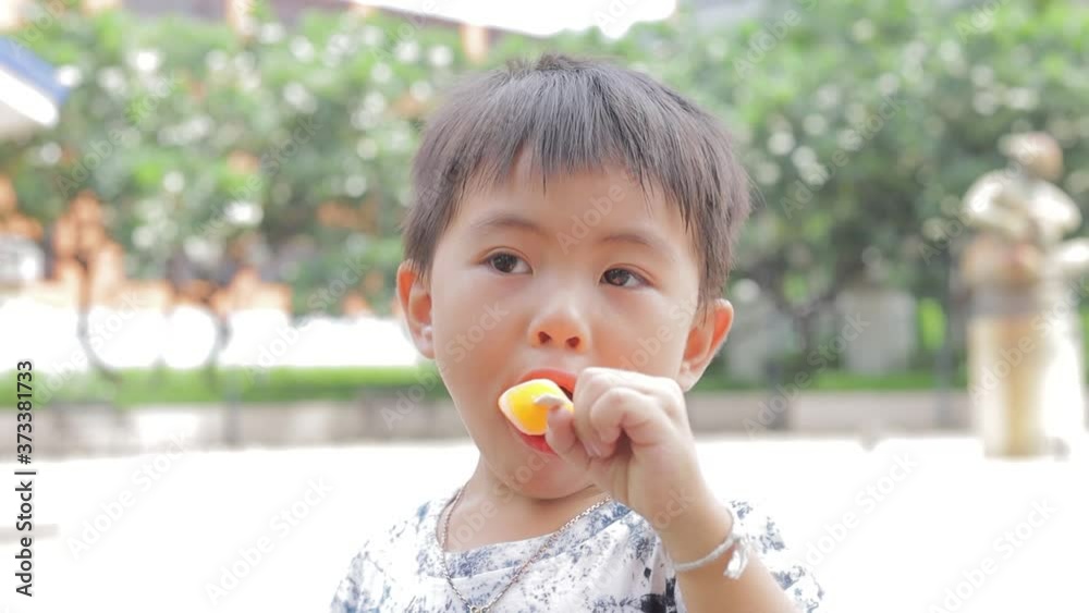 Little asian boy eating ice cream. Boy screams and eats ice cream Little asian boy eating ice cream. Boy screams and eats ice cream