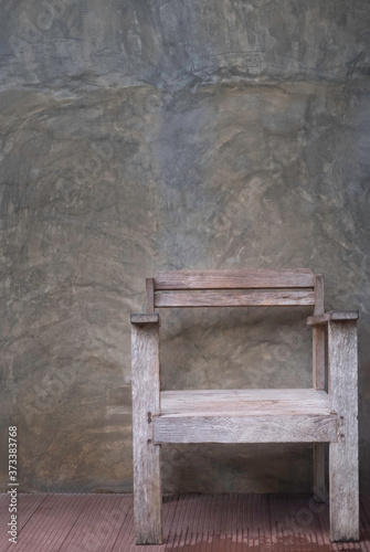 Empty, wooden old chair with old dirty cement color grey wall vintage background. Empty free space.