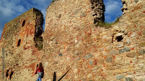 Woman walking around the ruined walls of Bauska Castle in Latvia photo