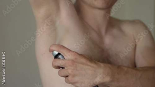 Spray On Antiperspirant Deodorant Being Applied To Male Right Armpit. Close Up