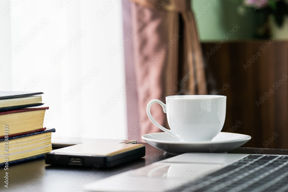 Coffee cup and laptop with book