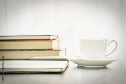 Coffee cup and laptop with book