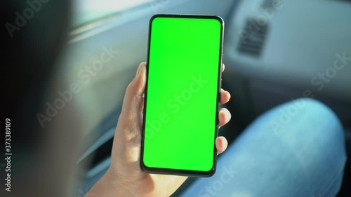 Close up of a woman's hand holding a mobile telephone with a vertical green screen in car chroma key smartphone technology cell phone street touch message display hand