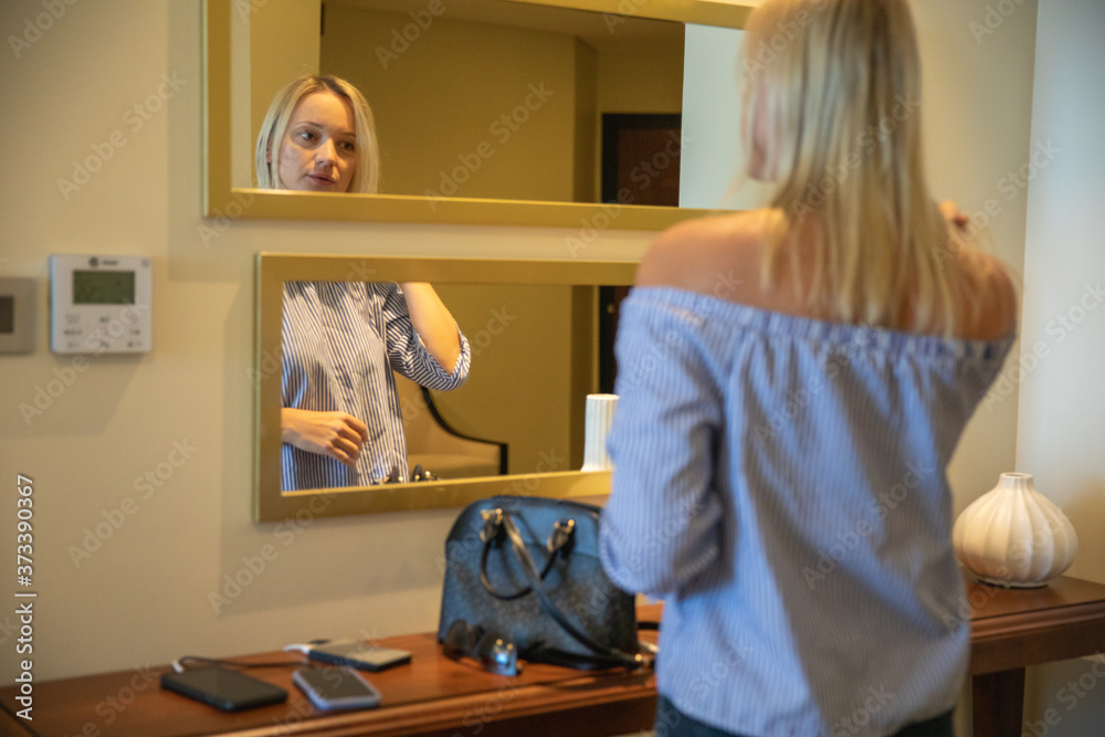 Young blonde Woman coming home and charging phones with portable charging device Young blonde Woman coming home and charging phones with portable charging device