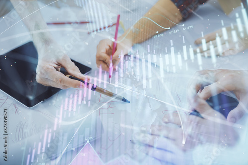 Double exposure of forex graph drawing and man and woman working together holding and using a mobile device. Trade concept.