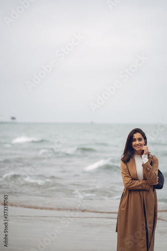 young girl walking on the beach during autumn